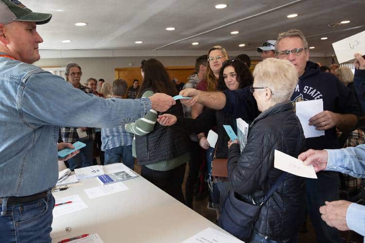 Ballot clerk hands out ballots at School District Annual Meeting